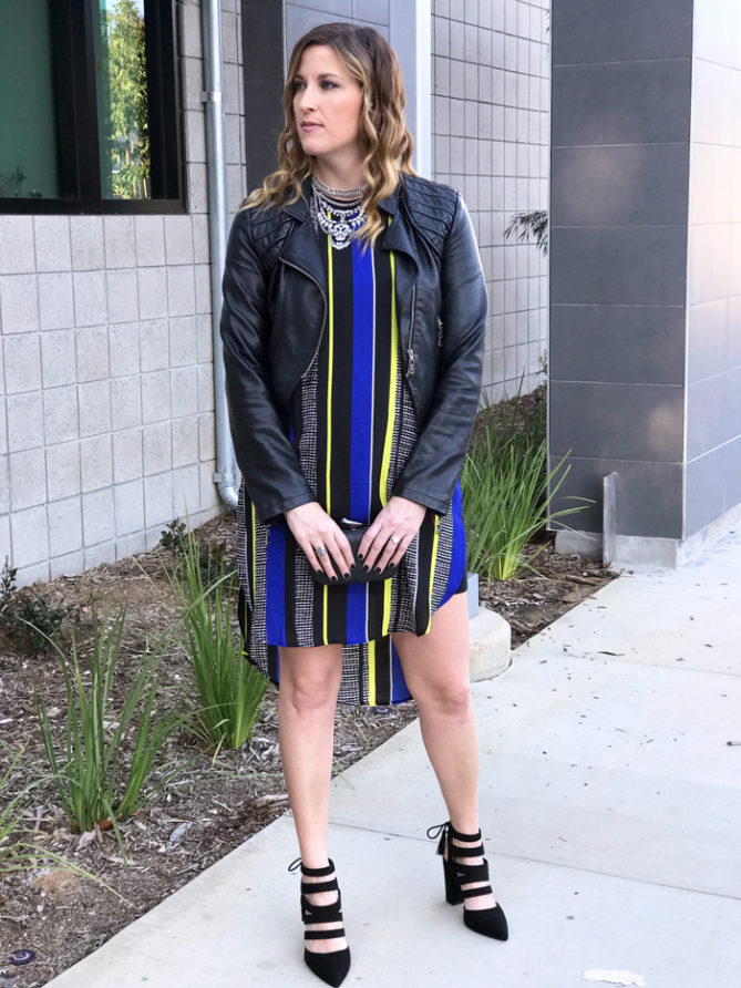 A printed dress paired with a leather jacket and statement necklace.