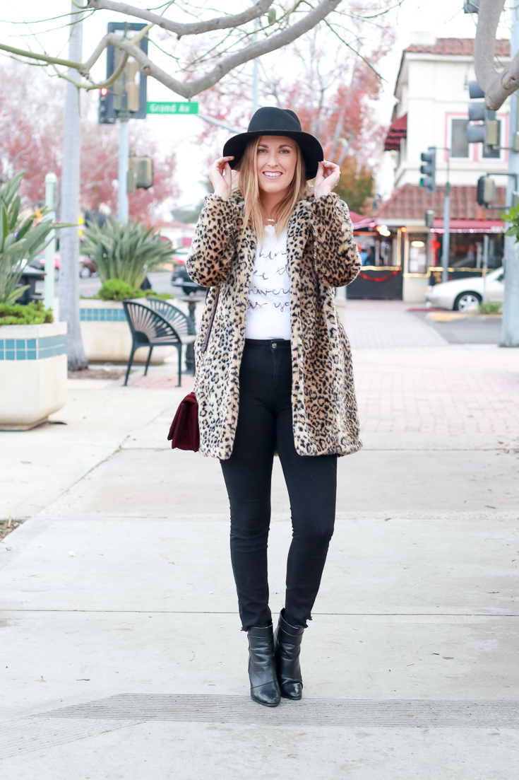 The Fashionista Momma shares a leopard print coat, velvet purse and black denim.