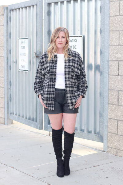 4 Ways To Wear A Shacket featured by popular US Style Blogger, Style & Wanderlust: photo of woman wearing leather shorts and a plaid shacket.